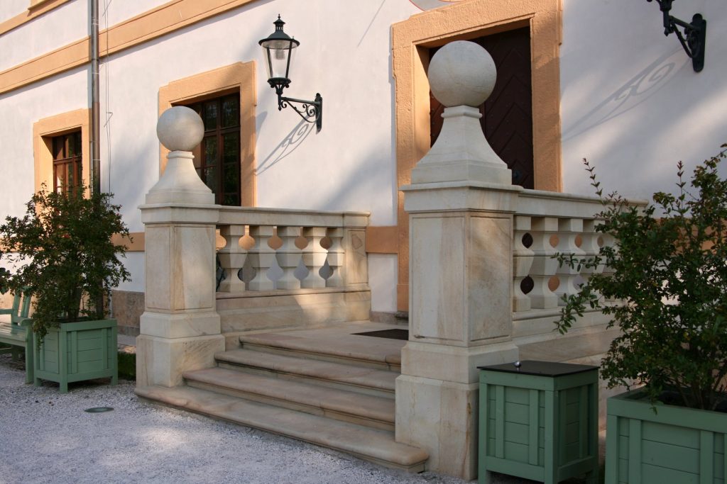 Pískovcové schody na zámku Kuks z extrémně tvrdého pískovce z kamenolomu Vyhnánov, zdobené historickými detaily, vedoucí k baroknímu areálu. Pískovcové schody na zámku Kuks z extrémně tvrdého pískovce z kamenolomu Vyhnánov, zdobené historickými detaily, vedoucí k baroknímu areálu.