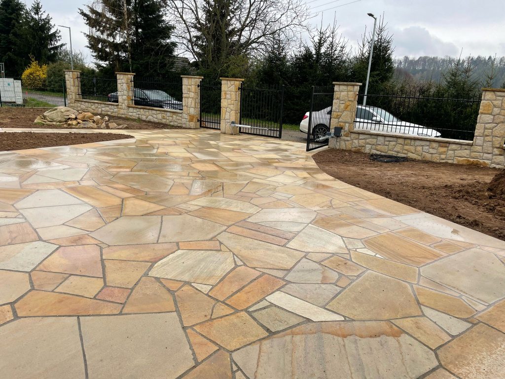 Vjezd do areálu u srubu s dlažbou z anglické dlažby z pískovce Vyhnanského lomu, které vytvářejí elegantní a harmonický vstup do zahrady. Přírodní struktura kamene krásně ladí s kamenným plotem. Pískovcová dlažba - vjezd do areálu u srubu s dlažbou z anglické dlažby z pískovce z Vyhnánovského lomu, které vytvářejí elegantní a harmonický vstup do zahrady. Přírodní struktura kamene krásně ladí s kamenným plotem.