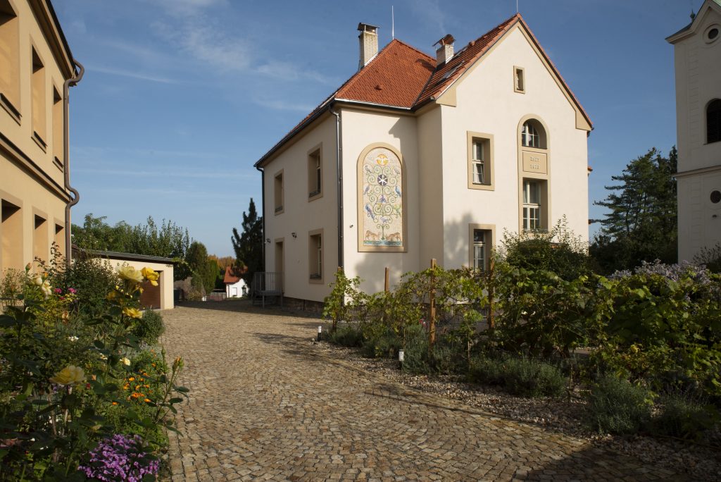 Fara Radotín Pohled na zrekonstruovanou faru v Radotíně a novou příjezdovou cestu z dlažebních kostek.